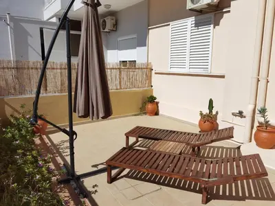 a patio with two benches and an umbrella at Beautiful apartment with 3 bedrooms in Archangelos