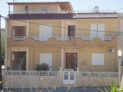 a large yellow house with a balcony and stairs at Beautiful apartment with 3 bedrooms in Archangelos