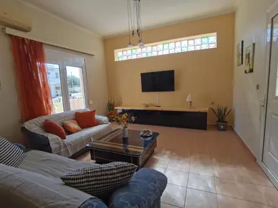 a living room with a couch and a tv at Beautiful apartment with 3 bedrooms in Archangelos