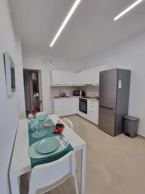 a white kitchen with a table and a refrigerator at Danae Luxury Apartment - Rhodes in Rhodes Town