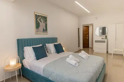 a bedroom with a blue and white bed with pillows at Danae Luxury Apartment - Rhodes in Rhodes Town
