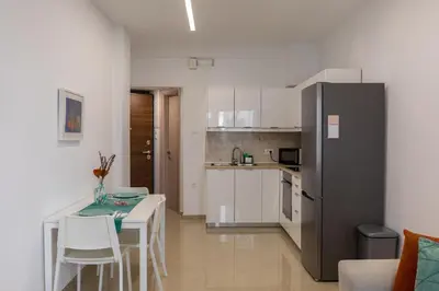 a small kitchen with a table and a refrigerator at Danae Luxury Apartment - Rhodes in Rhodes Town
