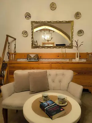 a room with a couch with a table and a mirror at Rustic House Archangelos in Archangelos