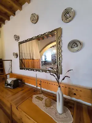 a bathroom with a mirror and a vase on a table at Rustic House Archangelos in Archangelos