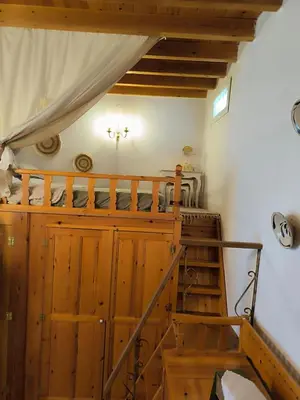 a room with a bunk bed and a staircase at Rustic House Archangelos in Archangelos