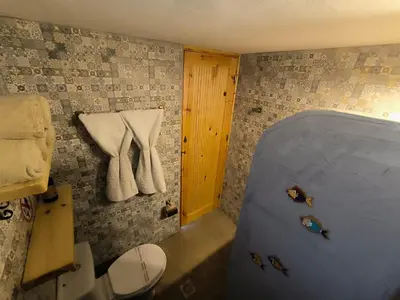 a bathroom with a tub and a toilet at Rustic House Archangelos in Archangelos
