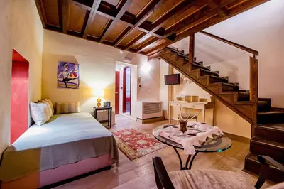 a bedroom with a bed and a spiral staircase at Avalon Boutique Hotel Rhodes in Rhodes Town