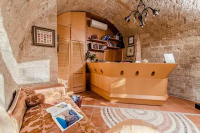 a living room with a counter in a stone wall at Avalon Boutique Hotel Rhodes in Rhodes Town