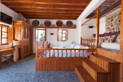 a bedroom with two beds and a desk at Melenos Art Boutique Hotel in Líndos