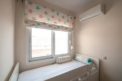 a small room with a window with stars on the curtain at Saint Francis Apartment in Rhodes Town