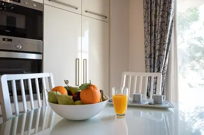 a bowl of fruit on a table with a glass of orange juice at Saint Francis Apartment in Rhodes Town