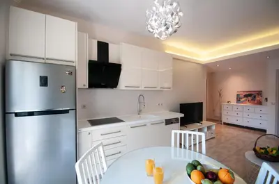 a kitchen with white cabinets and a table with fruit on it at Saint Francis Apartment in Rhodes Town