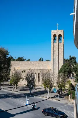 a car parked in front of a building with a clock tower at Saint Francis Apartment in Rhodes Town