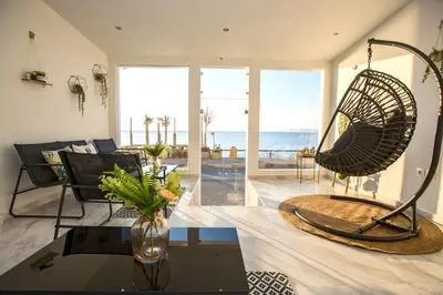 a living room with a table and a swing at Sea Side Rooms in Rhodes Town