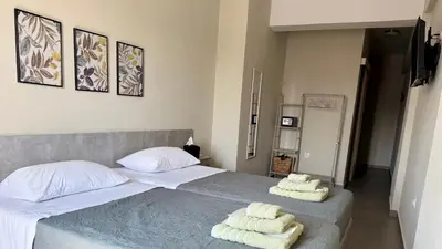 a bedroom with a large bed with towels on it at Sea Side Rooms in Rhodes Town