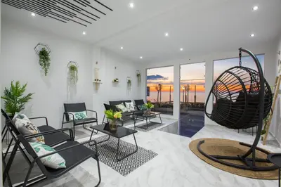 a living room with chairs and a large swing at Sea Side Rooms in Rhodes Town