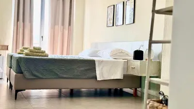 a bedroom with a bed with a green comforter at Sea Side Rooms in Rhodes Town