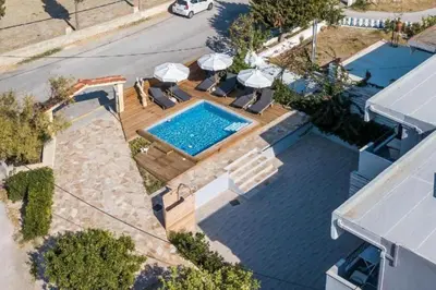 an overhead view of a swimming pool with chairs and umbrellas at Pagona Studios in Faliraki