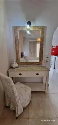 a bathroom with a vanity with a mirror and a chair at Pagona Studios in Faliraki