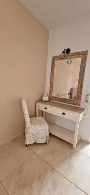 a dressing table with a mirror and a chair at Pagona Studios in Faliraki