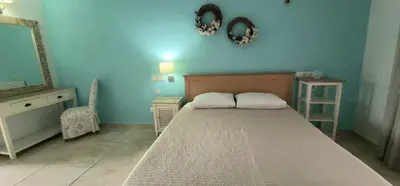 a bedroom with a bed and a blue wall at Pagona Studios in Faliraki
