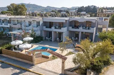 a large white building with a swimming pool at Pagona Studios in Faliraki
