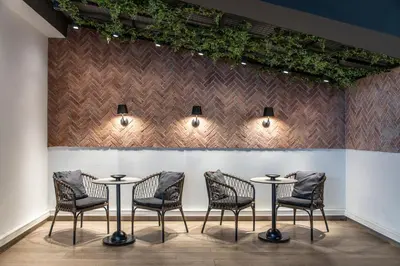a row of tables and chairs in front of a wall at Eden Roc Resort - All Inclusive in Kallithea Rhodes