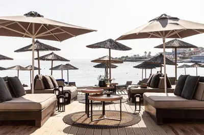 a restaurant with couches and tables and umbrellas at Eden Roc Resort - All Inclusive in Kallithea Rhodes