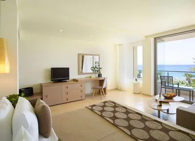 a living room with a view of the ocean at The Ixian Grand & All Suites - Adults Only Hotel in Ixia