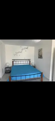 a bedroom with a bed with a blue bedspread at Jacob Apartments in Center of Rhodes in Rhodes Town