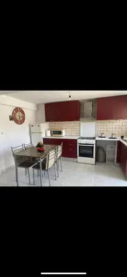 a kitchen with red cabinets and a table and chairs at Jacob Apartments in Center of Rhodes in Rhodes Town