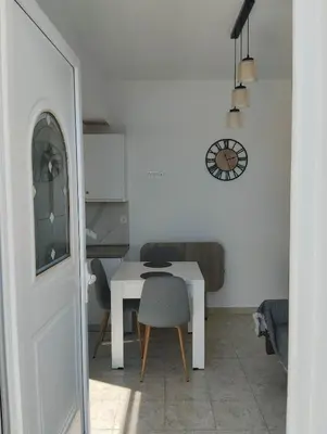 a white room with a table and a chair at Palma Apartment in Faliraki