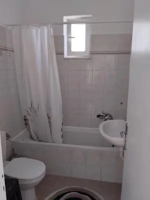 a bathroom with a toilet and a tub and a sink at Palma Apartment in Faliraki