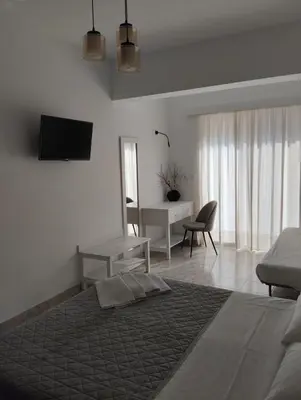 a bedroom with a bed and a desk and a television at Palma Apartment in Faliraki
