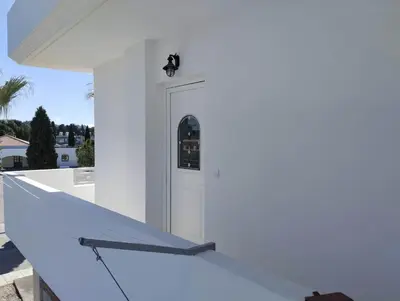 a white house with a white stairway at Palma Apartment in Faliraki