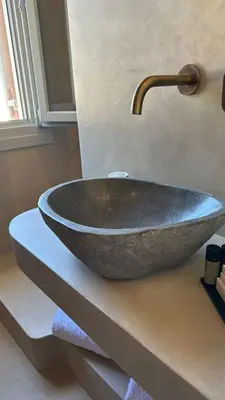 a bathroom sink with a large stone bowl at Amalthea Luxury Suites in Symi