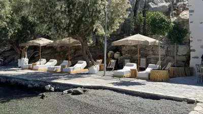 a group of chairs and umbrellas in a courtyard at Amalthea Luxury Suites in Symi