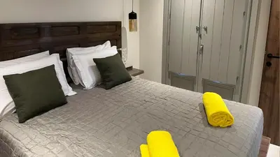 a bedroom with a bed with two yellow pillows at Amalthea Luxury Suites in Symi