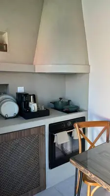 a kitchen with a stove top oven next to a table at Amalthea Luxury Suites in Symi