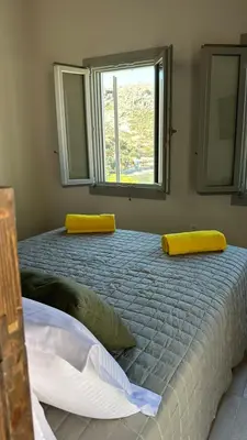 a bedroom with a large bed with a window at Amalthea Luxury Suites in Symi