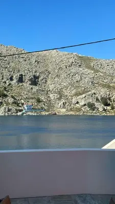a view of a body of water next to a mountain at Amalthea Luxury Suites in Symi