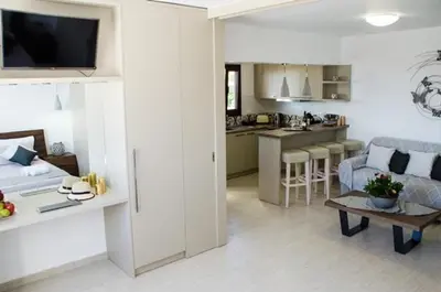 a living room and kitchen with a couch and a table at Helen Superior Suite in Líndos