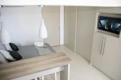 a white living room with a couch and a tv at Helen Superior Suite in Líndos