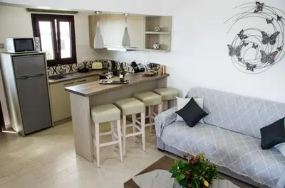 a living room with a couch and a kitchen at Helen Superior Suite in Líndos
