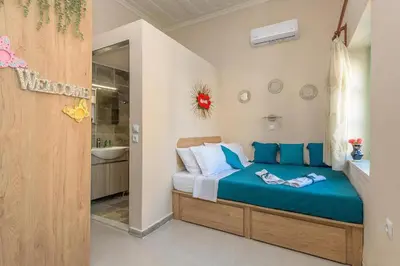 a bedroom with a blue bed and a bathroom at Rhodes Heaven Rose in Malona Village