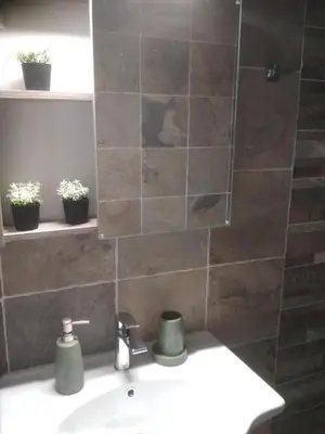 a bathroom with a sink and a tiled wall at Rhodes Heaven Rose in Malona Village