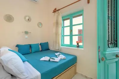 a bedroom with a blue bed with a window at Rhodes Heaven Rose in Malona Village