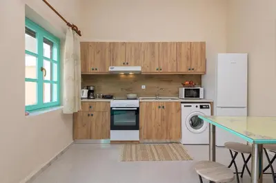 a kitchen with wooden cabinets and a white refrigerator at Rhodes Heaven Rose in Malona Village