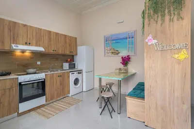 a kitchen with a refrigerator and a table in it at Rhodes Heaven Rose in Malona Village