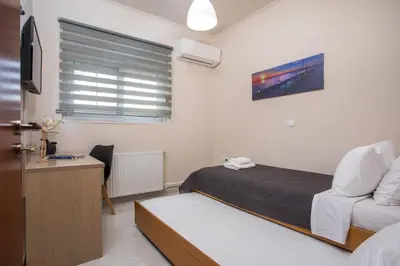 a bedroom with a bed and a chair and a window at Christina's House in Afantou